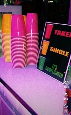 there are many different colored cups on the table and one sign that says taken single it's complicated