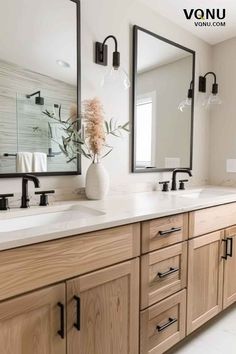 a large bathroom with double sinks and mirrors on the wall next to two vases filled with flowers