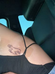 a woman with a tattoo on her stomach sitting in the back seat of a car