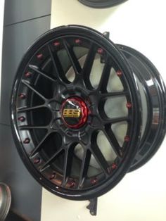 the wheels are black with red spokes on them, and there is also a tire in the background