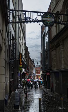 people walking down the street with umbrellas on a rainy day in an urban area