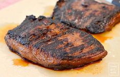 two steaks sitting on top of a cutting board