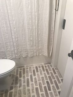 a white toilet sitting next to a shower in a bathroom