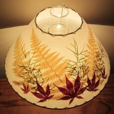 a lamp shade with leaves painted on it