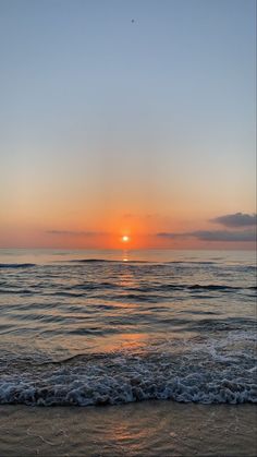 the sun is setting over the water at the beach