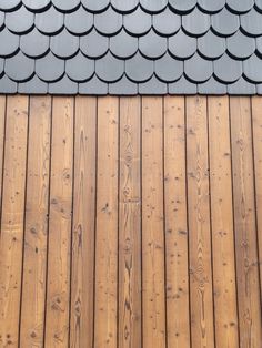 a close up view of a wooden roof with metal shingles on it's sides