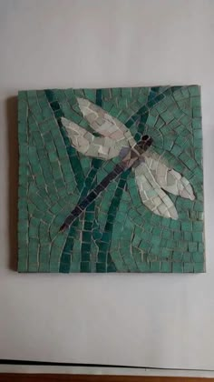 a dragonfly mosaic on a wall in a room