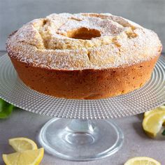 a cake on a glass plate with lemons around it