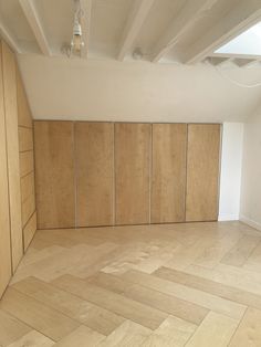 an empty room with wood paneling on the walls and hard wood parquet floor