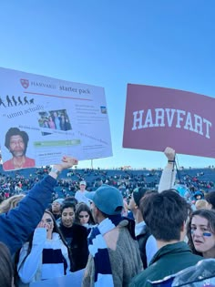 a crowd of people holding up signs in front of an audience at a sporting event