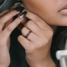 a close up of a person with rings on their fingers and one hand near her face