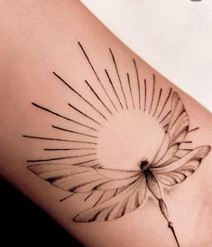 a woman's thigh with a tattoo design on the back of her leg and sunburst