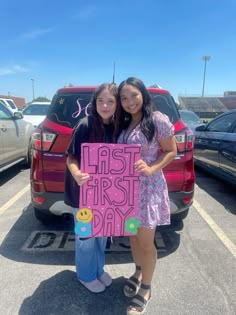 two girls standing next to each other holding up a sign that says last first day