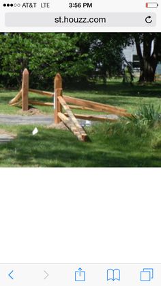 an image of a wooden gate in the grass with trees and bushes behind it, on instagram