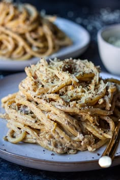 two plates filled with pasta on top of a table