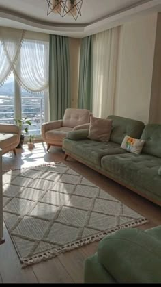 a living room with two couches and a rug in front of a window overlooking the city