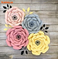 paper flowers are arranged on a wooden surface