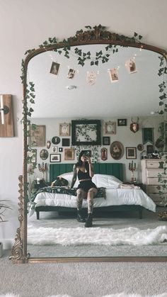 a woman taking a selfie while sitting on a bed in front of a mirror