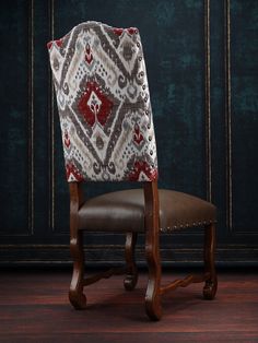 an upholstered wooden chair with a patterned back and seat cover on the side