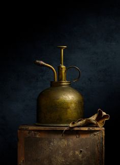 an old brass jug with a pipe sticking out of it