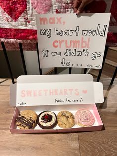 a box of doughnuts sitting on top of a wooden table next to a sign that says, may my heart would crumb if we didn't go