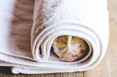 a towel rolled up on top of a wooden floor next to a piece of fruit