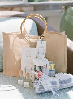 an assortment of crafting supplies sitting on a table next to a bag and pillow