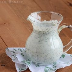 a glass pitcher filled with liquid sitting on top of a napkin