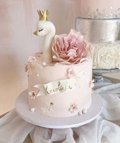 there is a pink cake with a swan on top and a rose in the middle