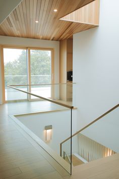 an empty room with wooden ceiling and glass railing