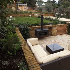 an outdoor living area with couches and a fire place