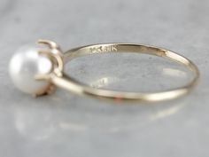 Perfect for stacking or even to wear alone, this minimalist pearl ring is as simple as can be. Crafted of yellow gold, six prongs hold a shining pearl. Metal: 10K/14K Yellow Gold Gem: Pearl Gem Measurements: 6.7 mm, Round Ring Size: 7.75 Marks: "10K 14K" Stamped on the inside band Luxury Elegant Everyday Pearl Ring, Cheap Wedding Pearl Ring With Metal Band, Luxury Stackable Round Pearl Ring, Yellow Gold Sapphire Ring, White Pearl Ring, Dream Wedding Ring, Pearl Rings, Freshwater Pearl Ring, Bangles Design