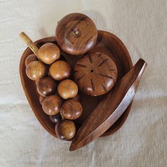 a wooden bowl with spoons and nuts in the shape of a heart on a white tablecloth