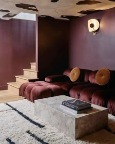 a living room with purple walls and white rugs on the floor next to a couch