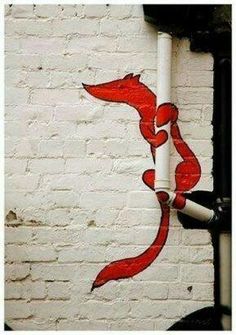 an image of a red fox painted on the side of a white brick building in russian