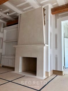 an unfinished room with a fireplace and white walls