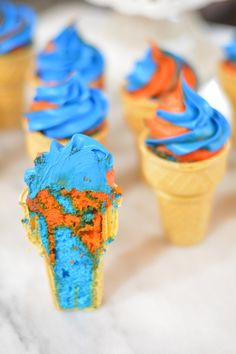 cupcakes with blue and orange frosting in cones