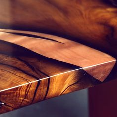 a close up of a wooden table with a knife sticking out of it's side