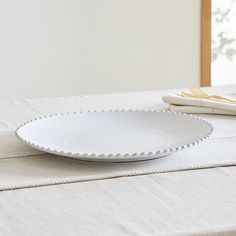 a white plate sitting on top of a table next to a fork and napkins