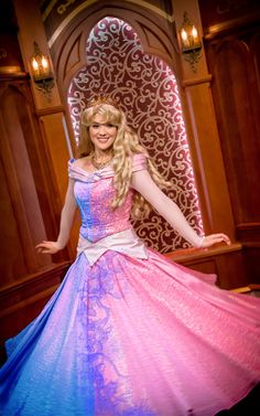 a woman in a pink and blue dress posing for the camera