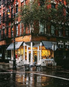 people are walking down the street in the rain