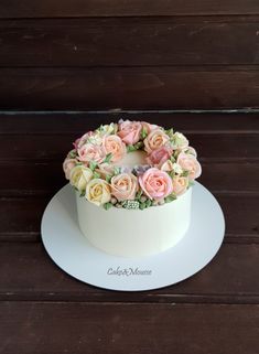 a white cake with pink and yellow flowers on top