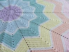 a crocheted blanket is laying on top of a tablecloth that has been knitted