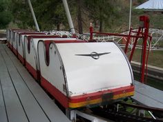 a white and red train car sitting on top of a wooden platform