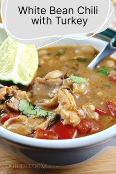 white bean chili with turkey in a bowl with lime and cilantro on the side