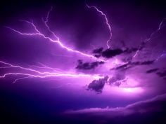 the sky is filled with purple lightning