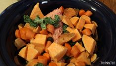 a black bowl filled with lots of cut up vegetables