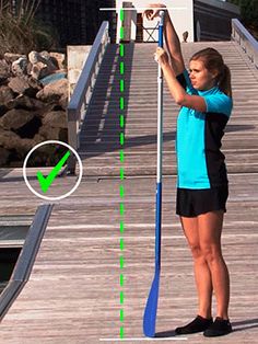 a woman standing on top of a wooden pier next to a green arrow pointing towards the water