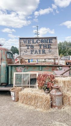 an old truck is parked in front of a sign that says welcome to the farm