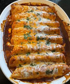 an enchilada dish on a plate with sauce and parmesan cheese